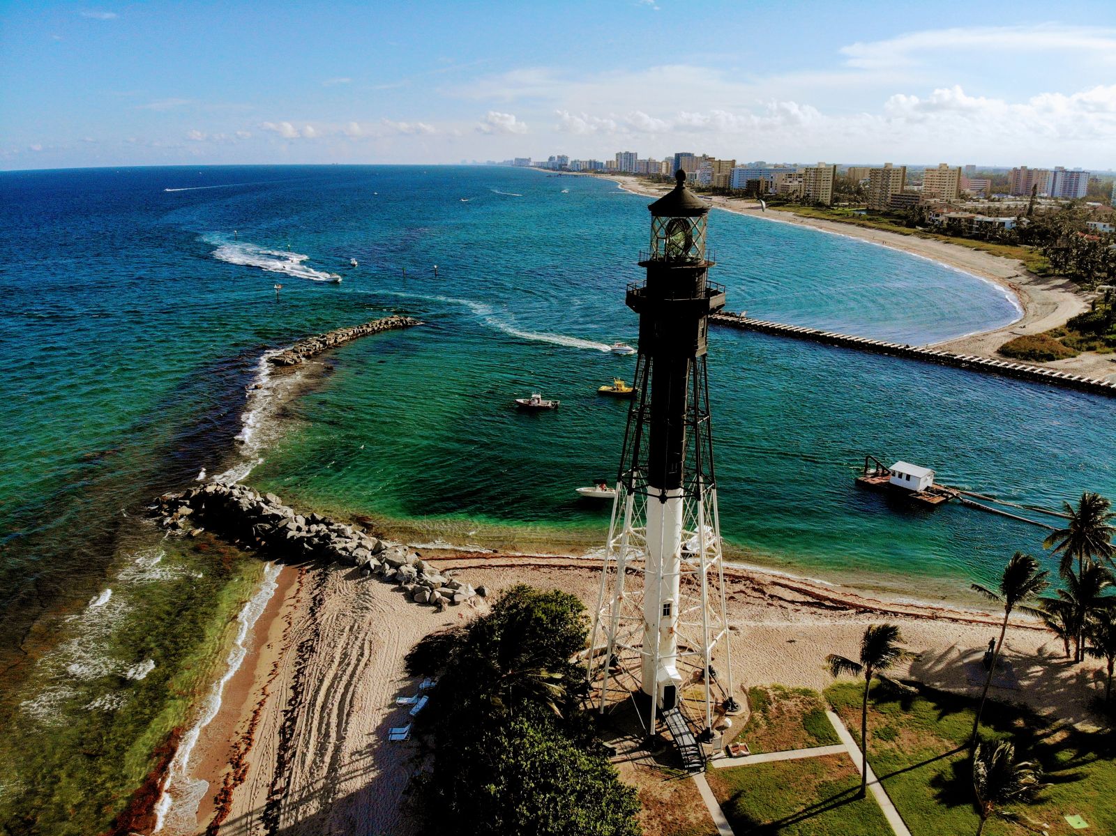 Aerial view of the historic black-and-white Hillsboro Inlet Lighthouse on the coast